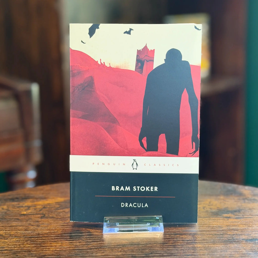 Book titled 'Dracula' by Bram Stoker on a wooden surface with a blurred background