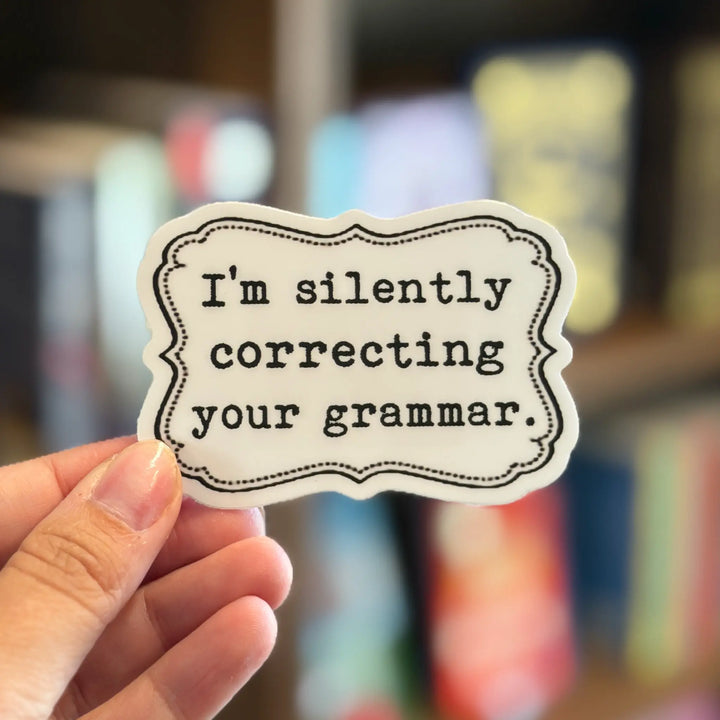 Hand holding a sticker with text &