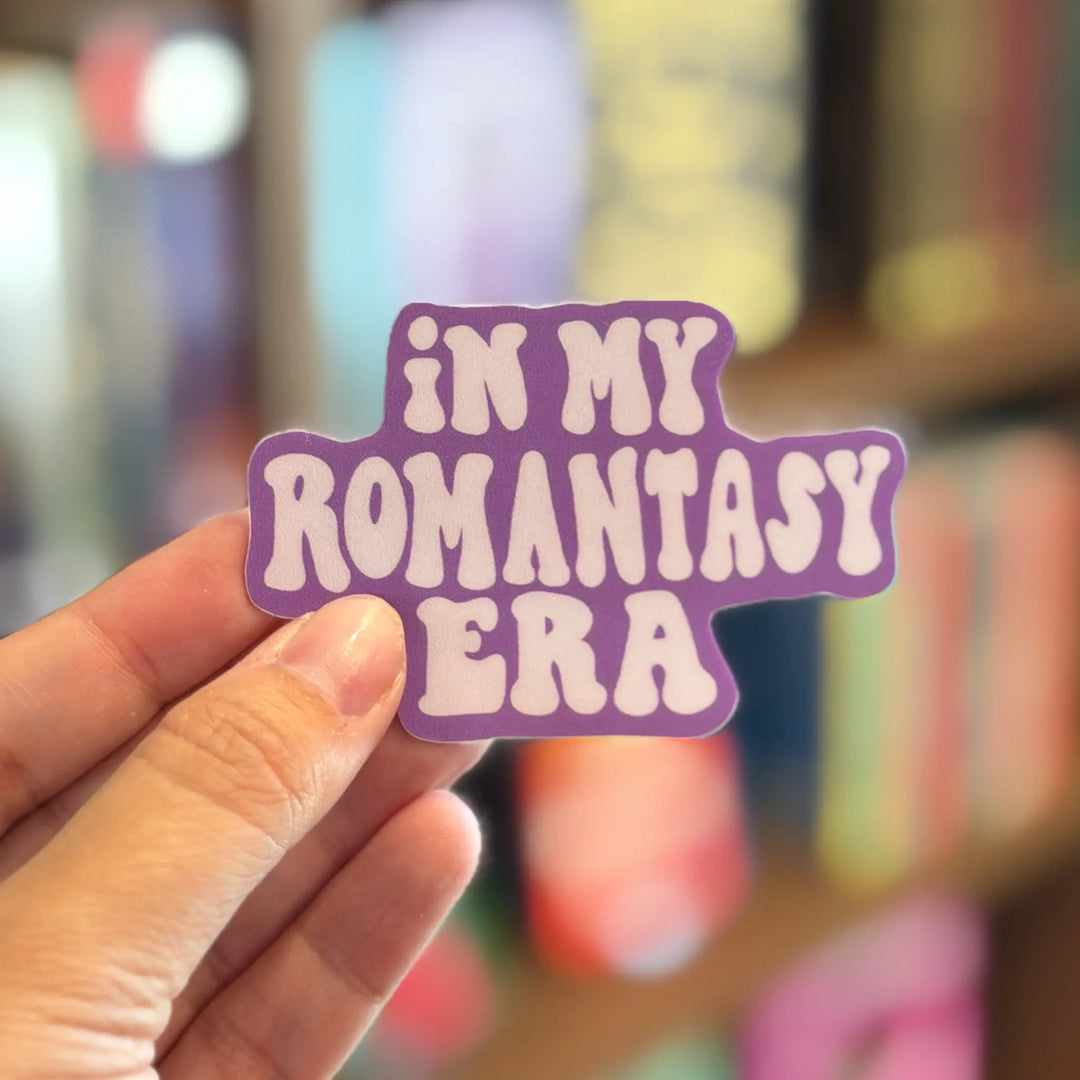 Hand holding a purple sticker with &