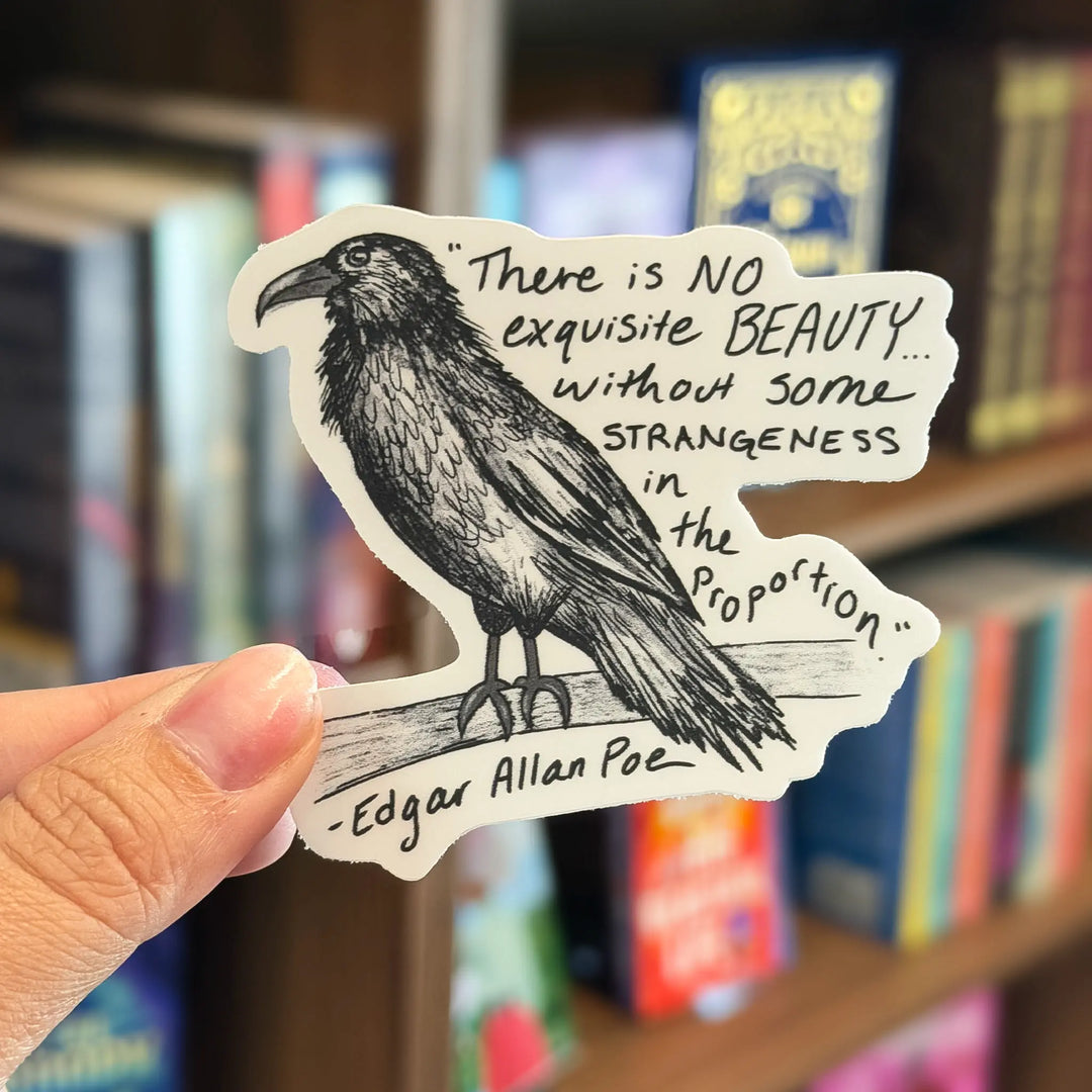 Sticker with a raven illustration and Edgar Allan Poe quote held in front of a bookshelf.