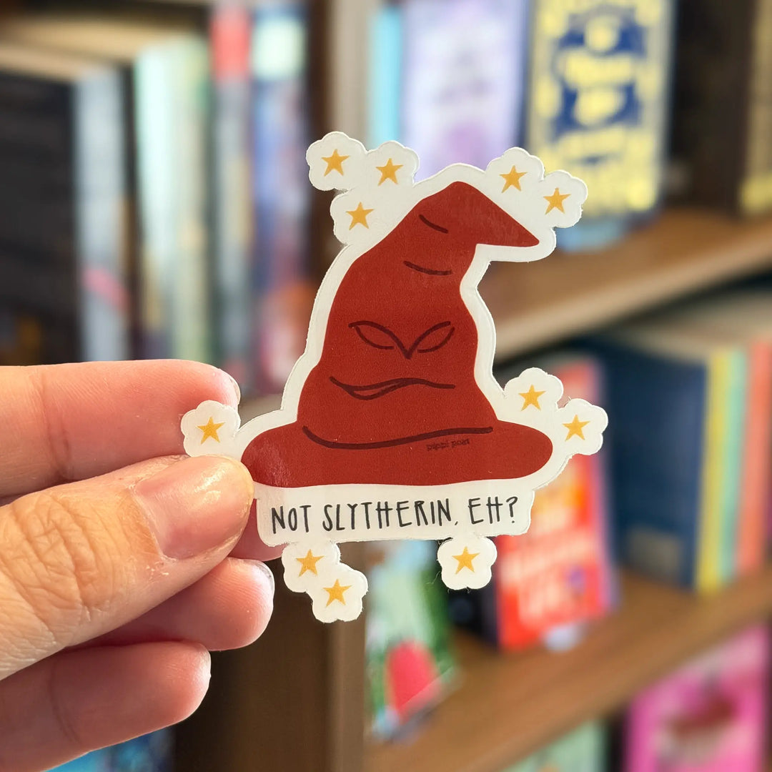 Hand holding a sticker with a Sorting Hat design and text &