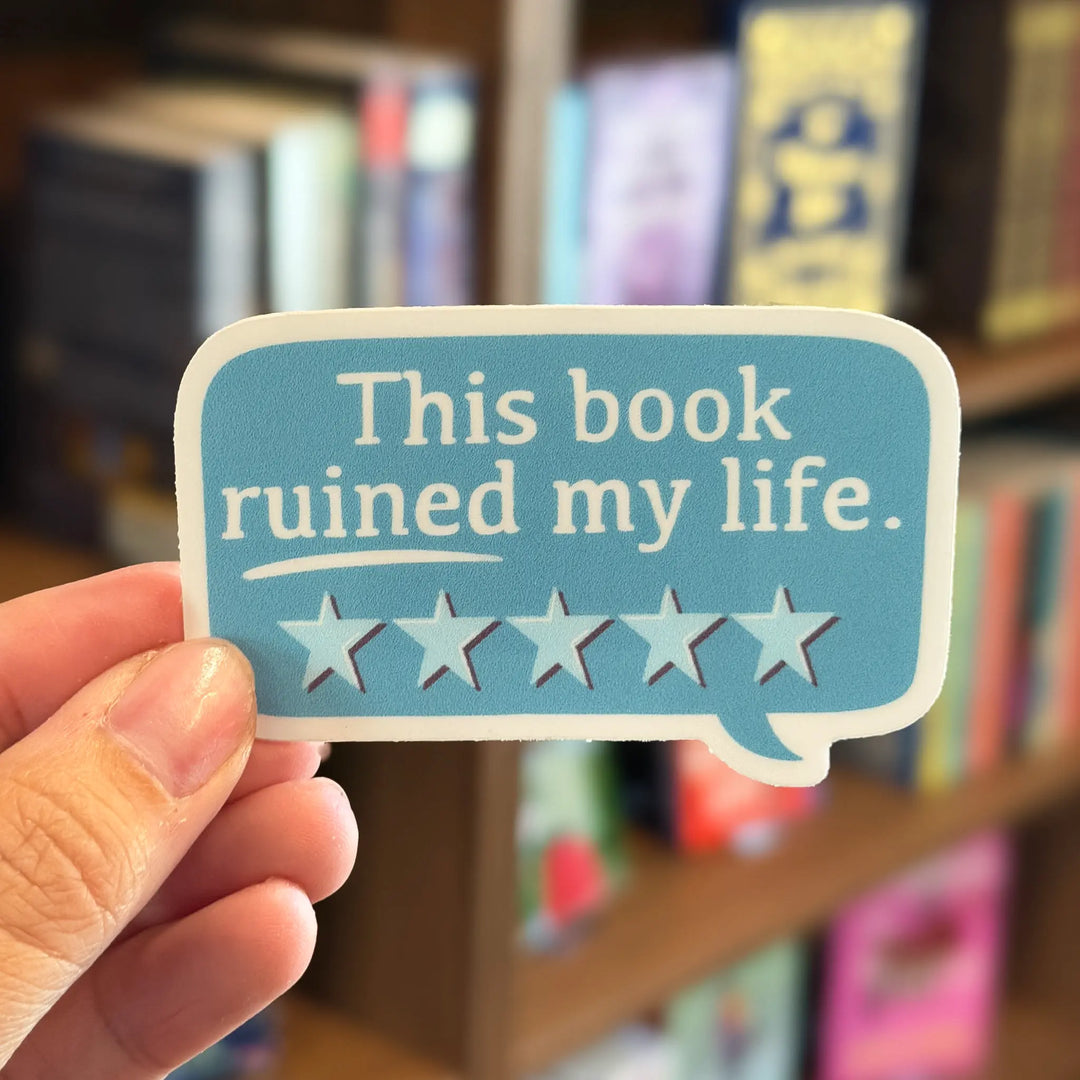 Hand holding a sticker with &