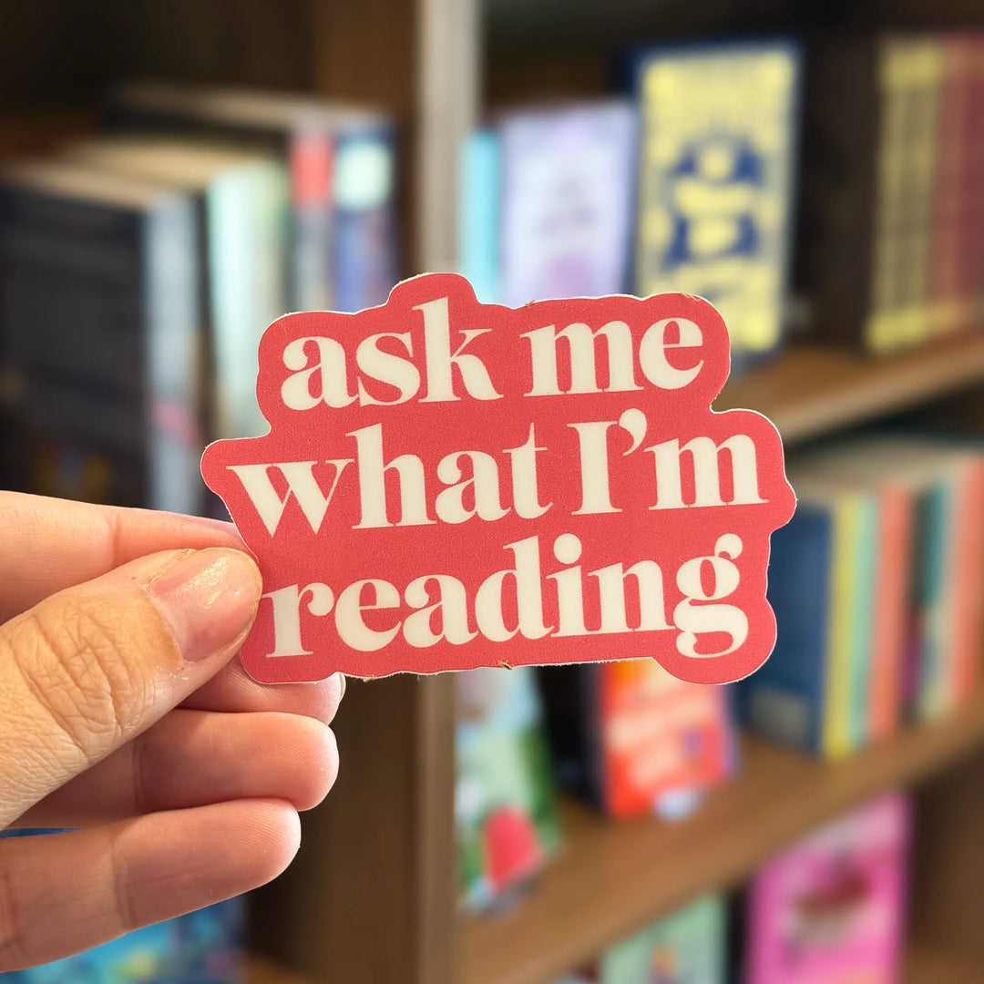Hand holding a red sticker with &