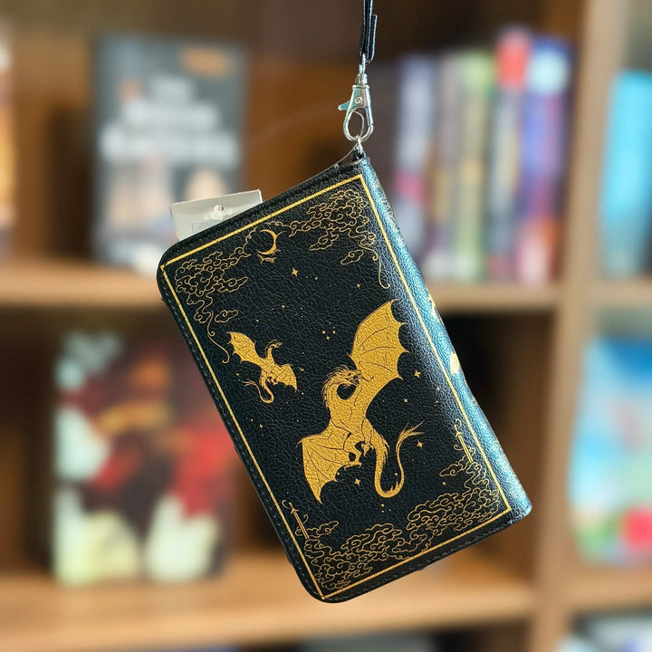 Black wallet with gold dragon design hanging against a bookshelf background