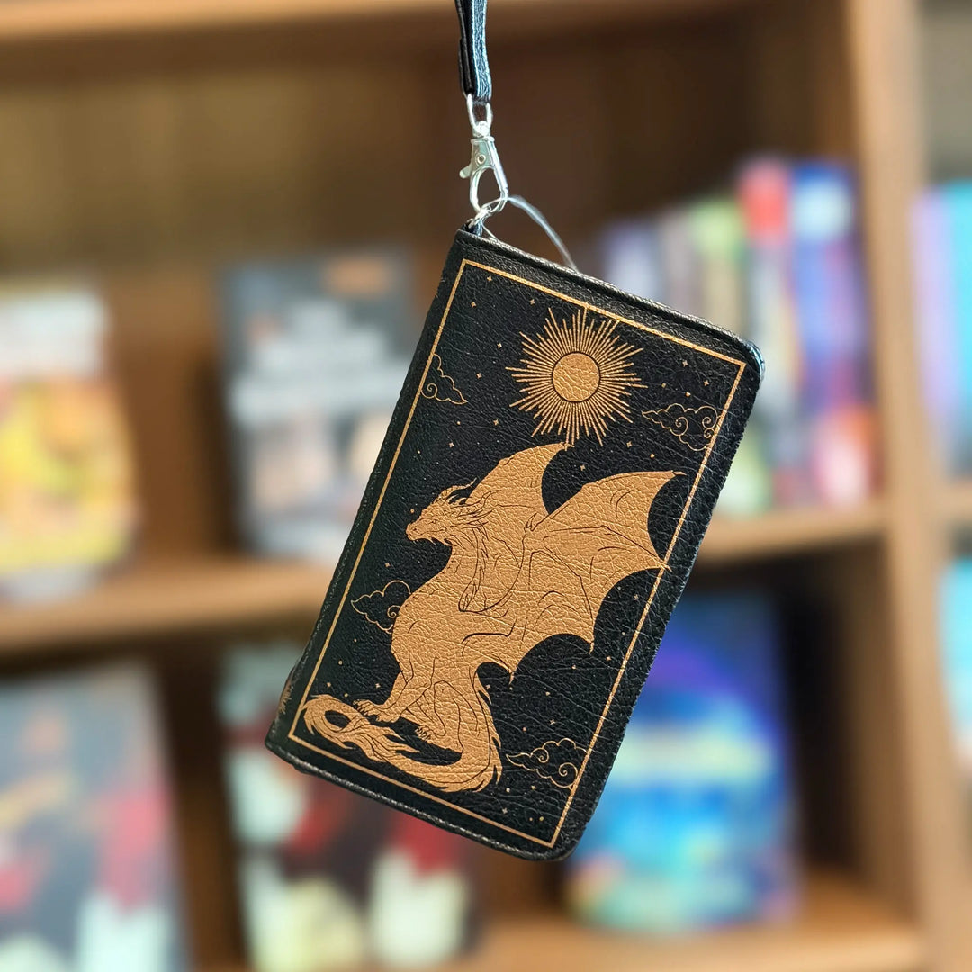 Black and gold dragon design on a card with a blurred bookshelf background