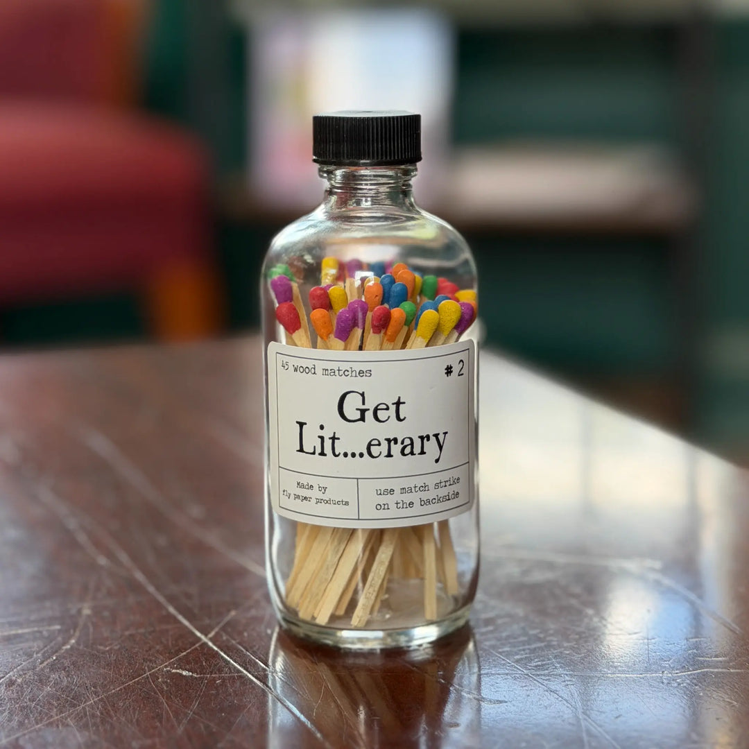 Bottle of colorful matches labeled 'Get Literary' on a wooden surface.