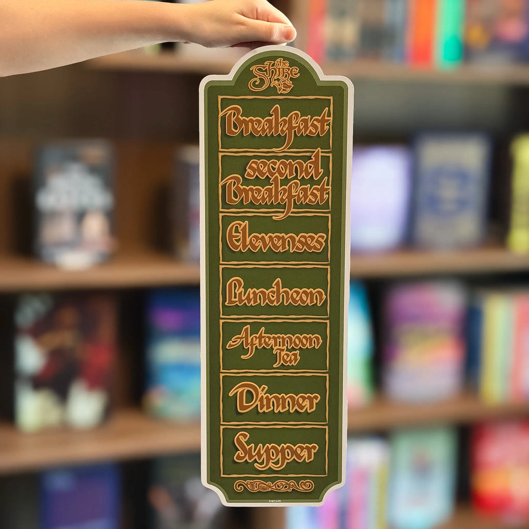 Decorative sign with meal times on a bookshelf background