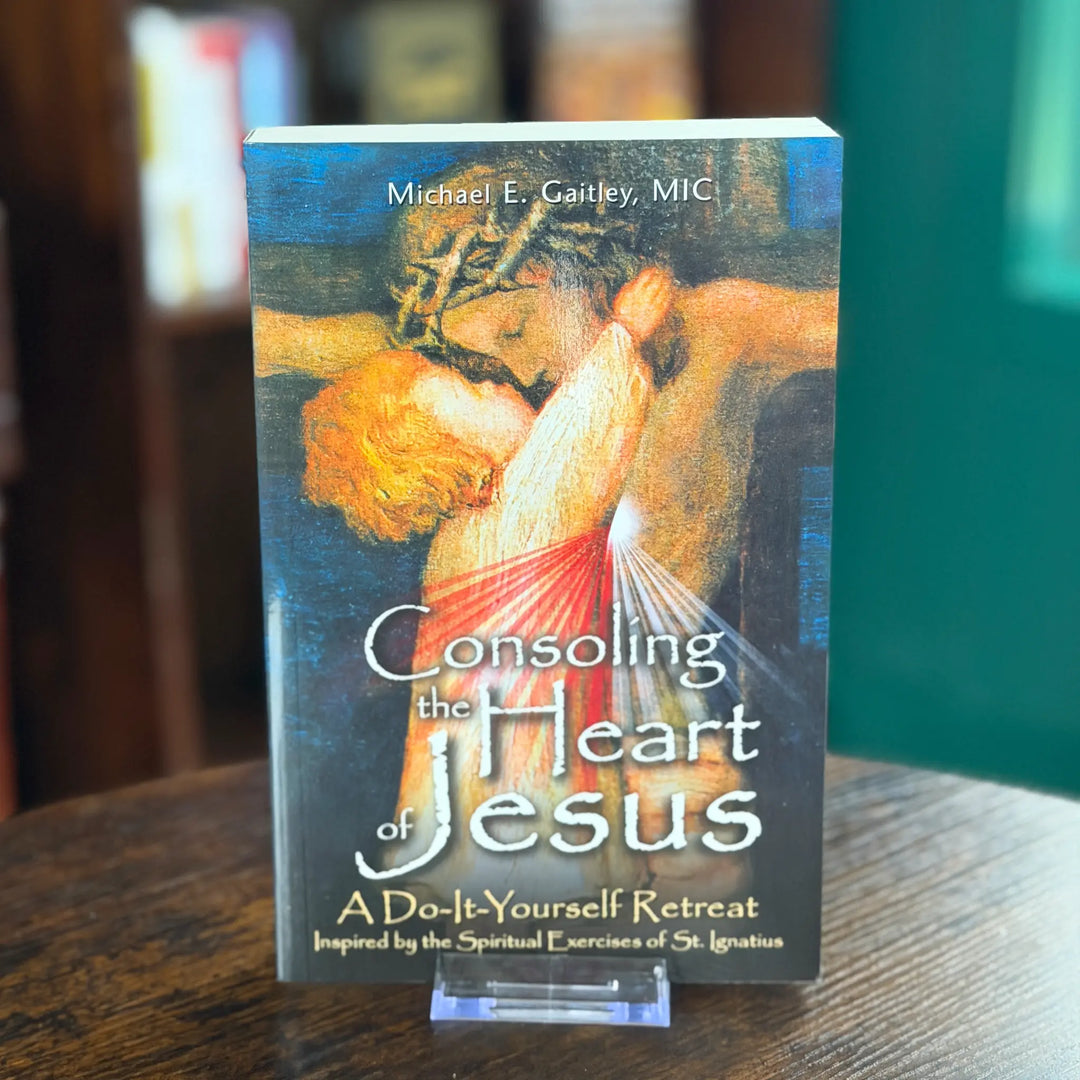 Book titled 'Consoling the Heart of Jesus' on a wooden surface with a blurred background