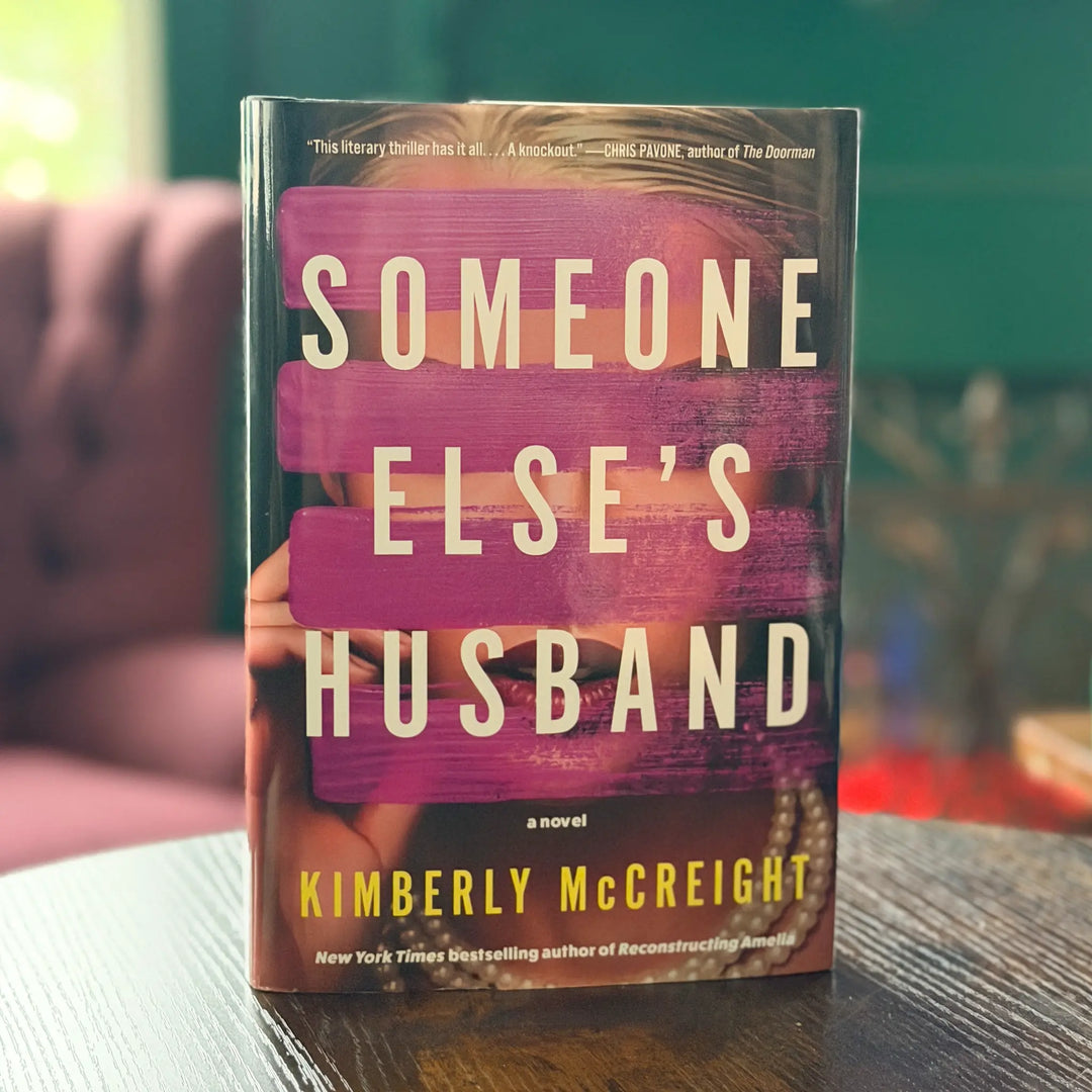Book titled 'Someone Else's Husband' by Kimberly McCreight on a table with a blurred background