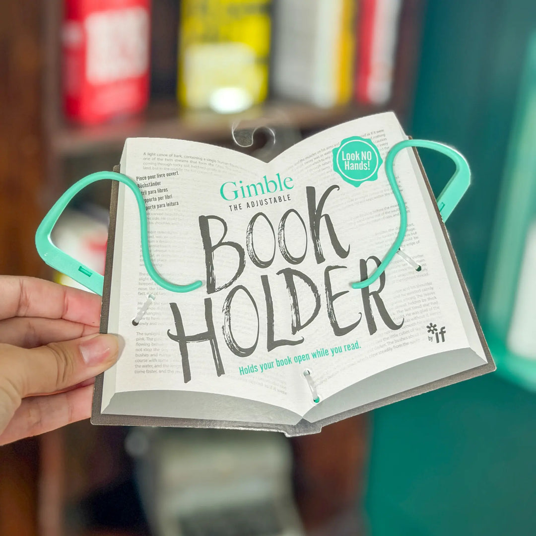 Book holder with adjustable straps holding an open book, with a blurred background.