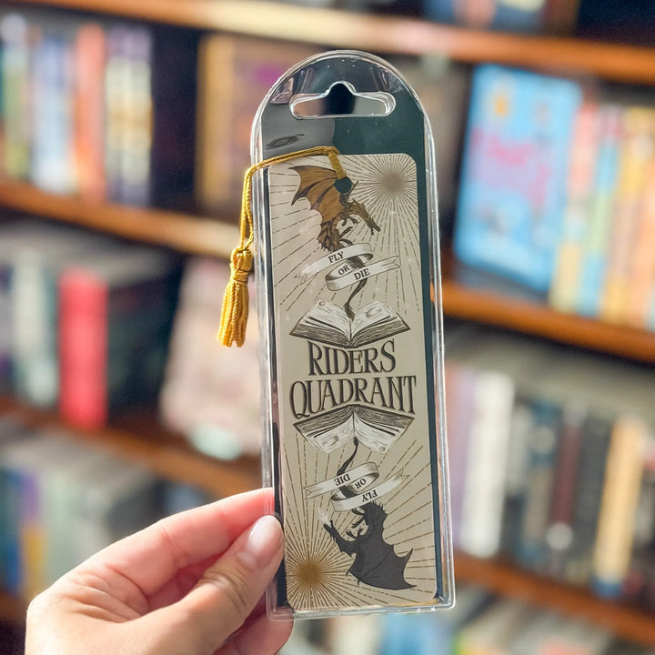 Bookmark in clear packaging held in front of a bookshelf