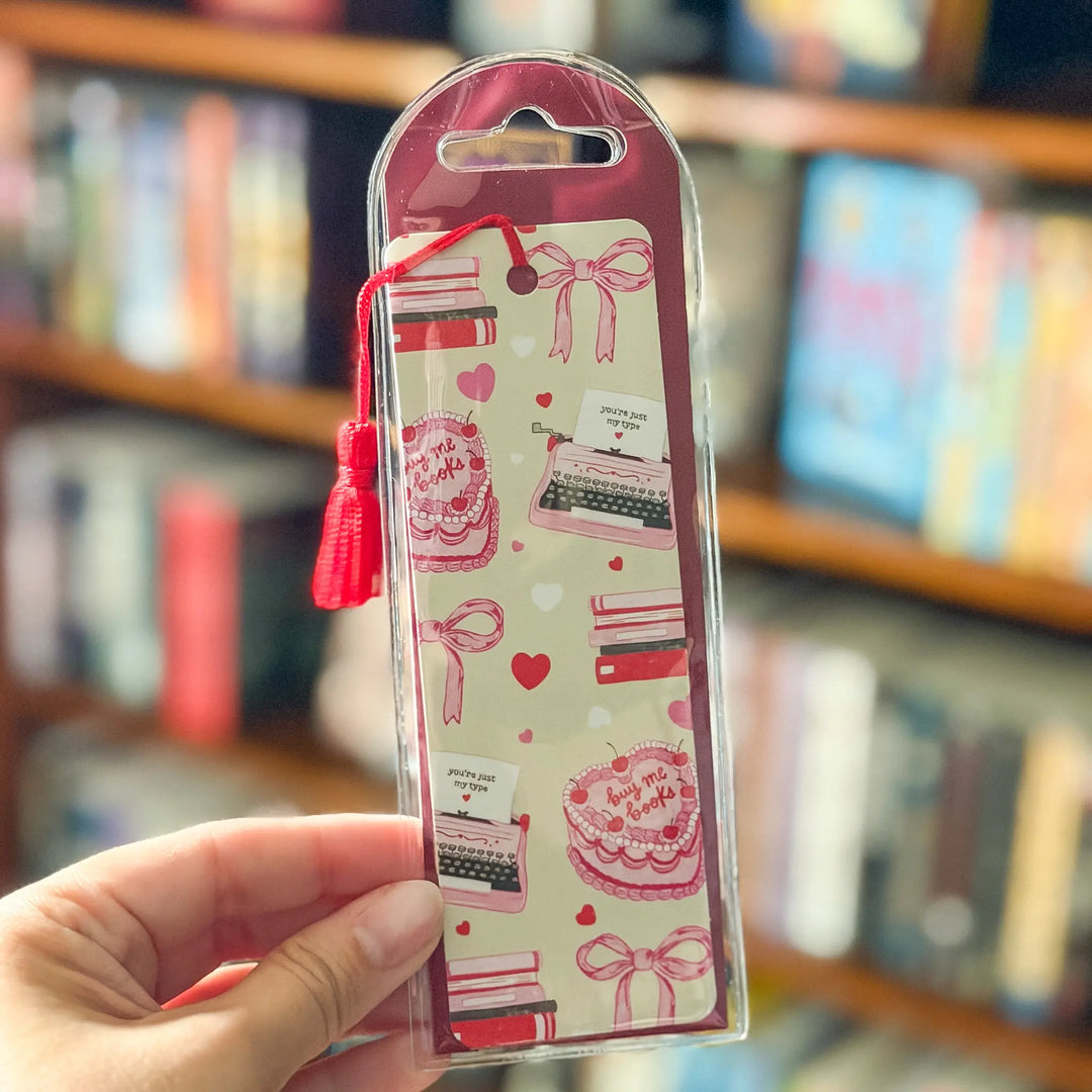 Packaged product with decorative design held in front of a bookshelf