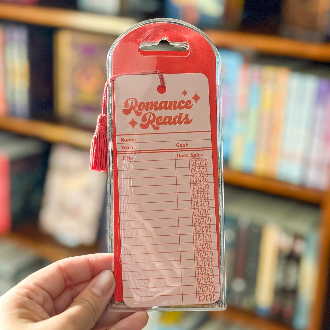 Plastic package with 'Romance Reads' label held in front of a bookshelf.