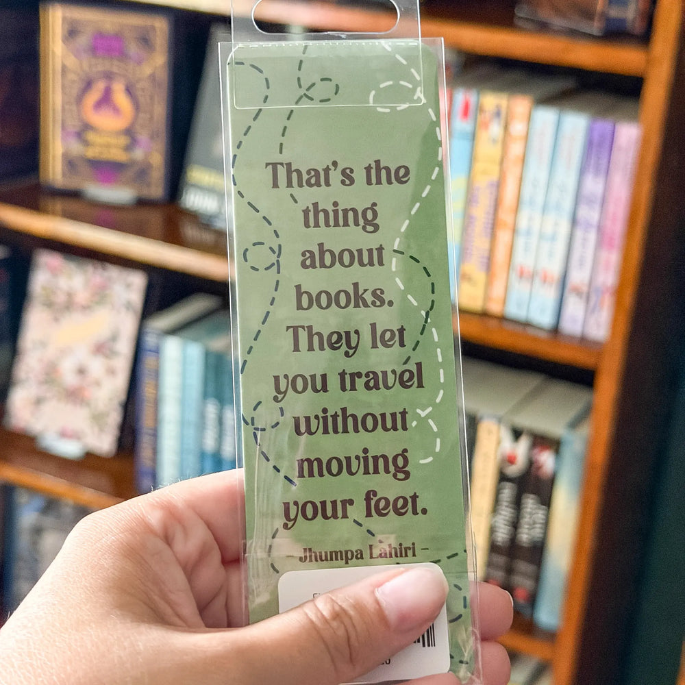 Hand holding a green bookmark with text in front of a bookshelf