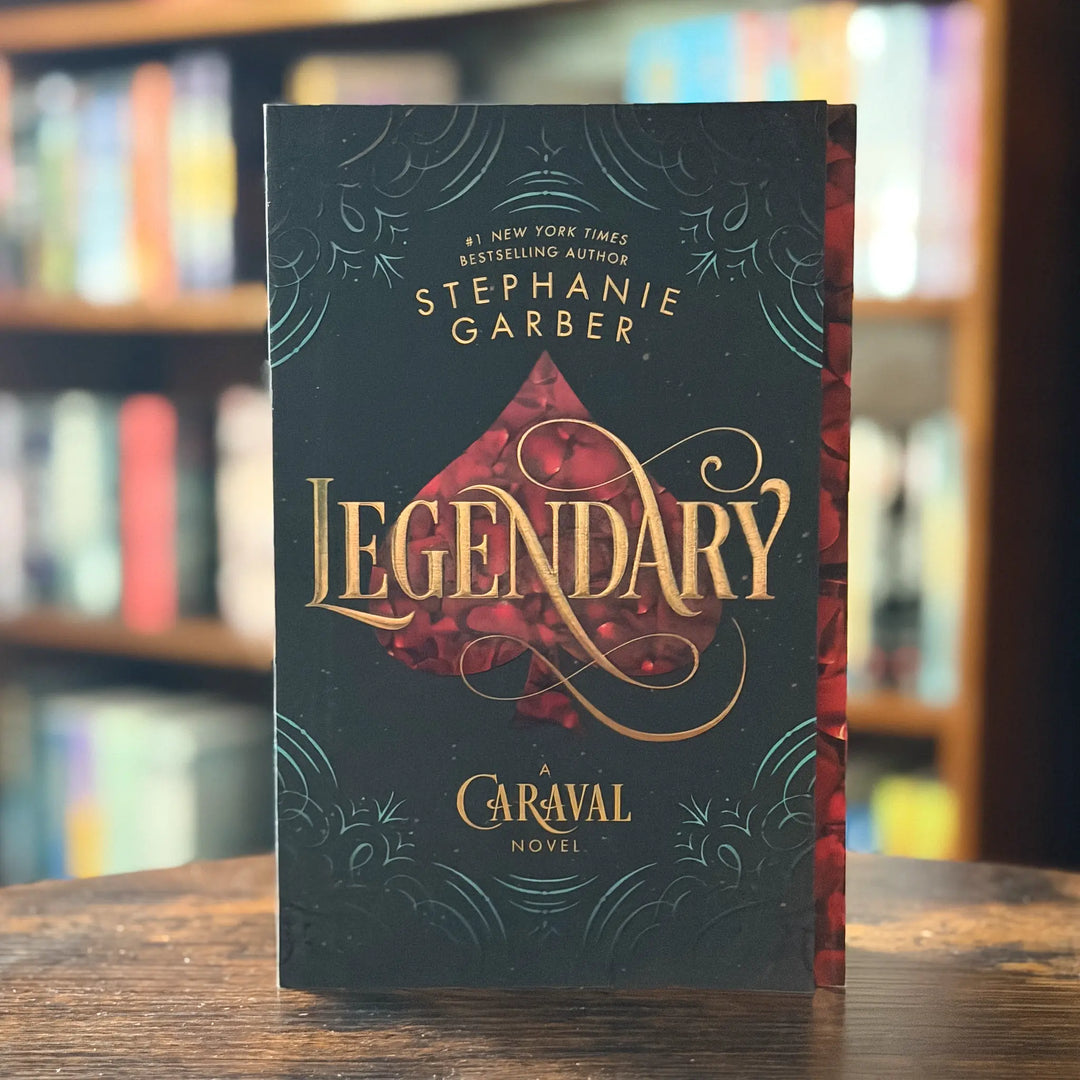 Book titled 'Legendary' by Stephanie Garber on a wooden surface with blurred bookshelf background
