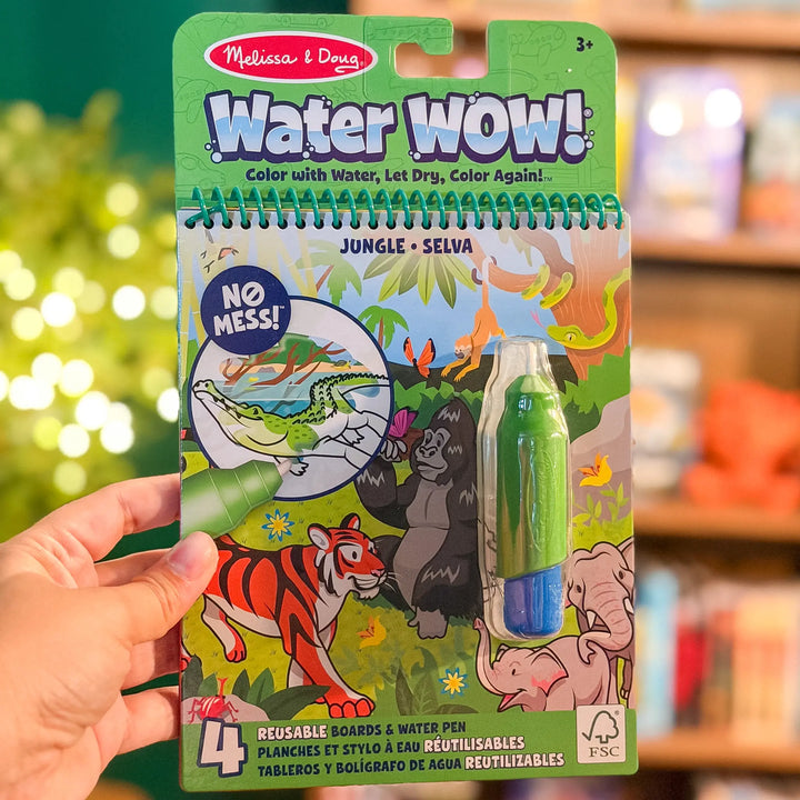 Melissa &amp; Doug Water Wow! Jungle coloring book with water pen held by a hand against a blurred indoor background.