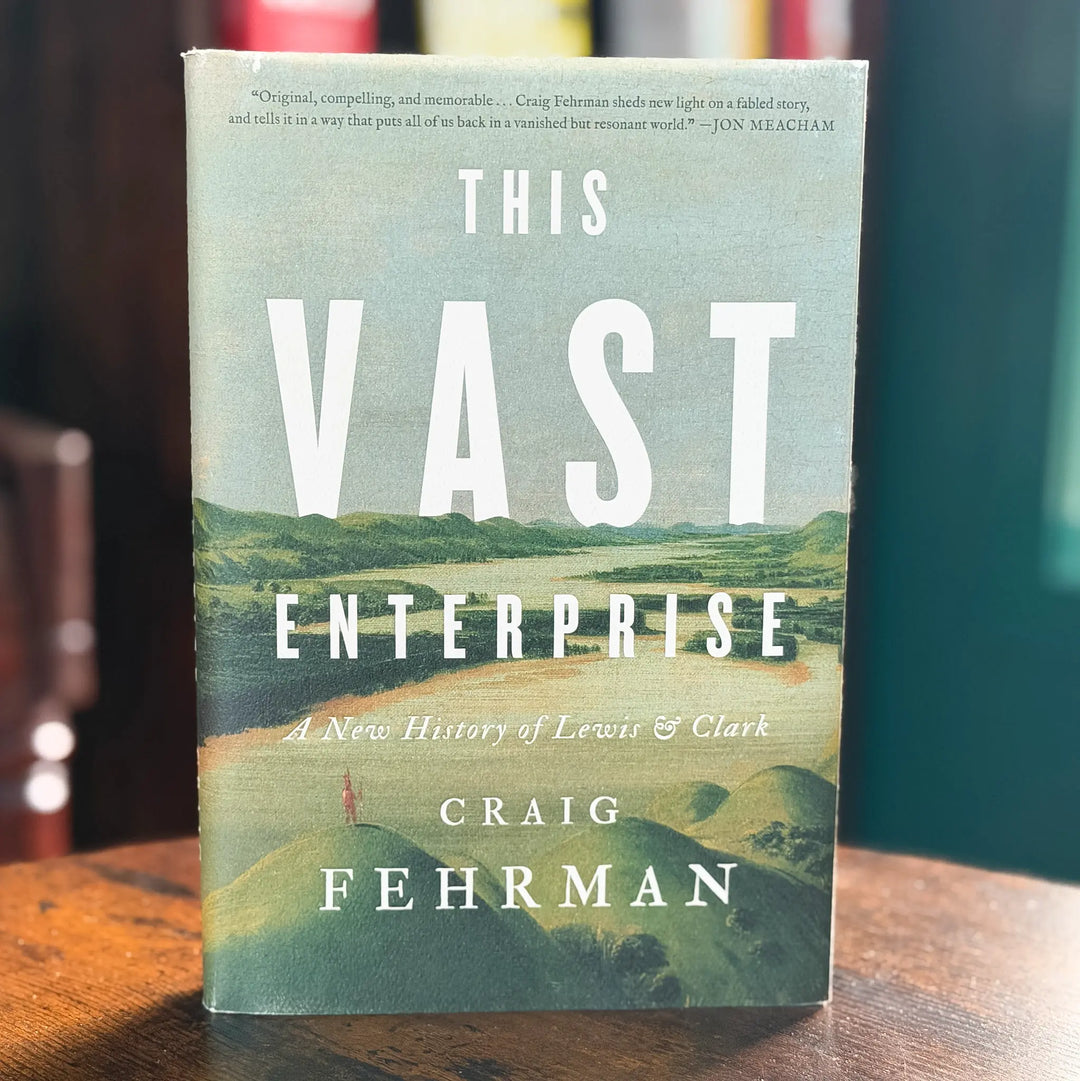 Book titled 'This Vast Enterprise' by Craig Fehrman on a wooden surface with a blurred background