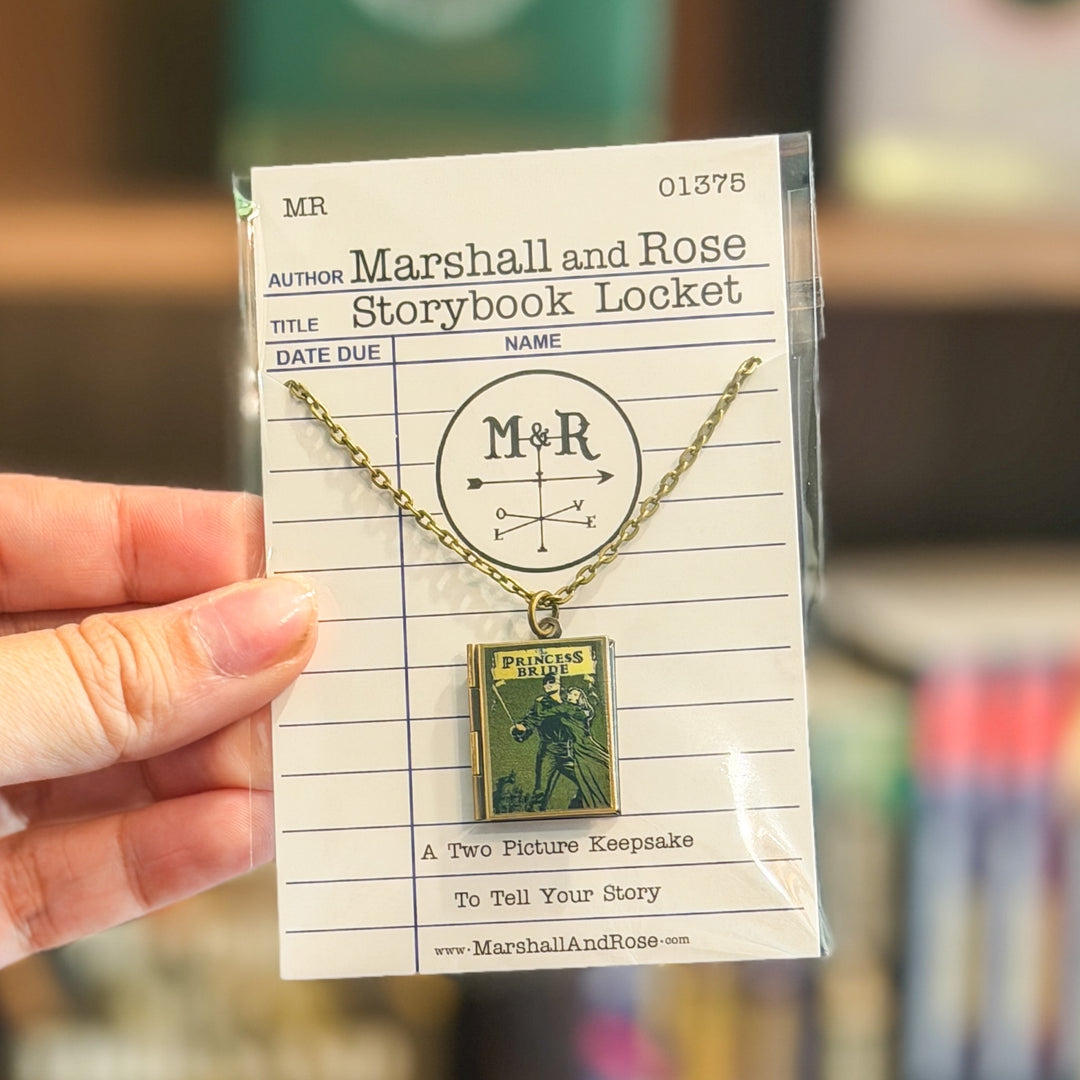 Necklace with 'M&R' design on a book-shaped pendant, displayed on a library card.