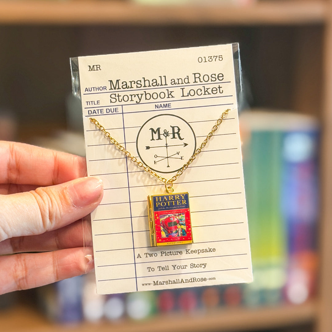 Gold necklace with a 'Harry Potter' book-shaped pendant on a card with 'Marshall and Rose' branding.