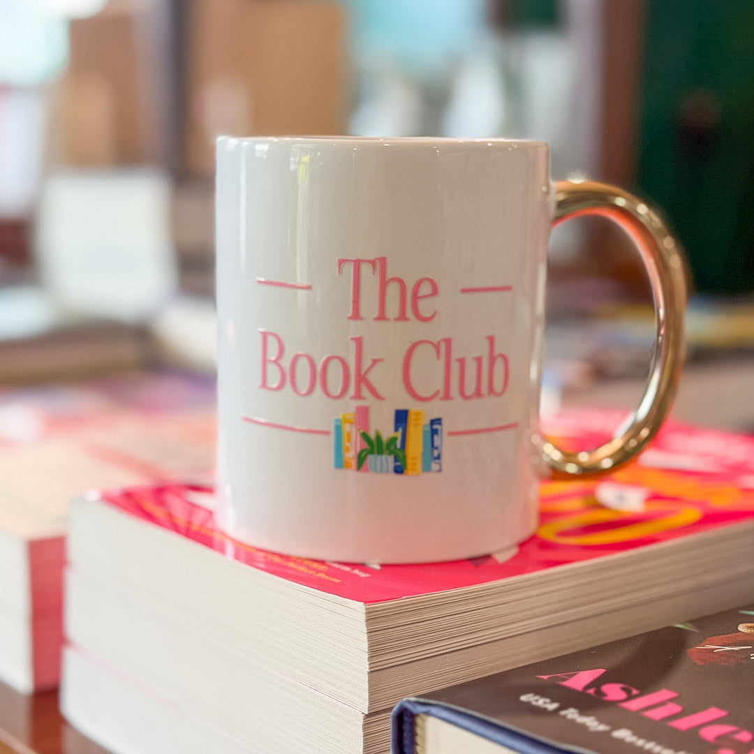 A white ceramic mug with a gold handle, printed with &