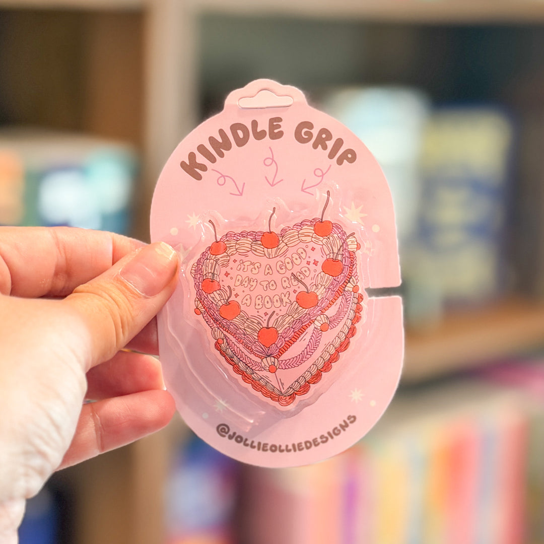 A hand holding a pink carded product labeled &