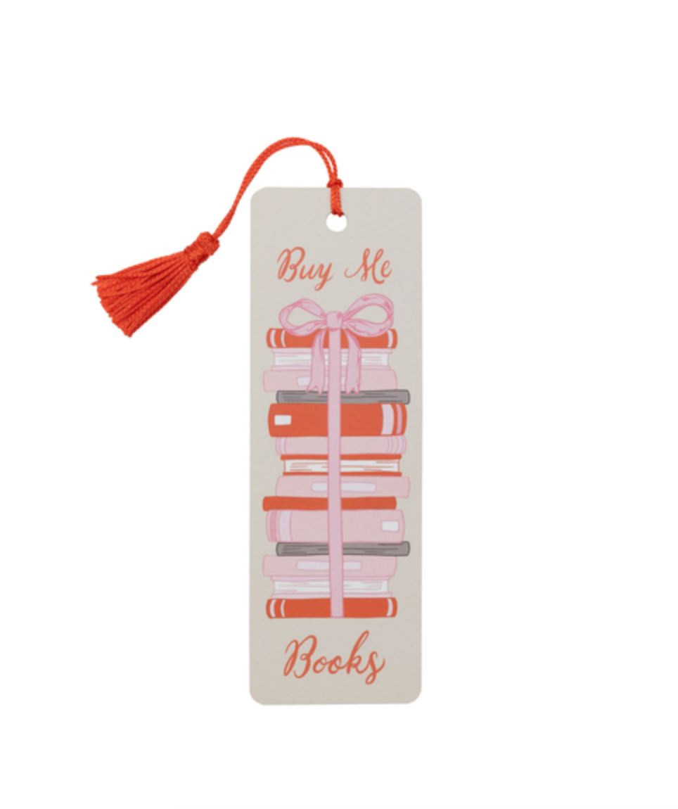 A rectangular bookmark with a tassel, featuring an illustration of a stack of books tied with a pink ribbon and the words 'Buy Me Books' in coral script, on a white background.