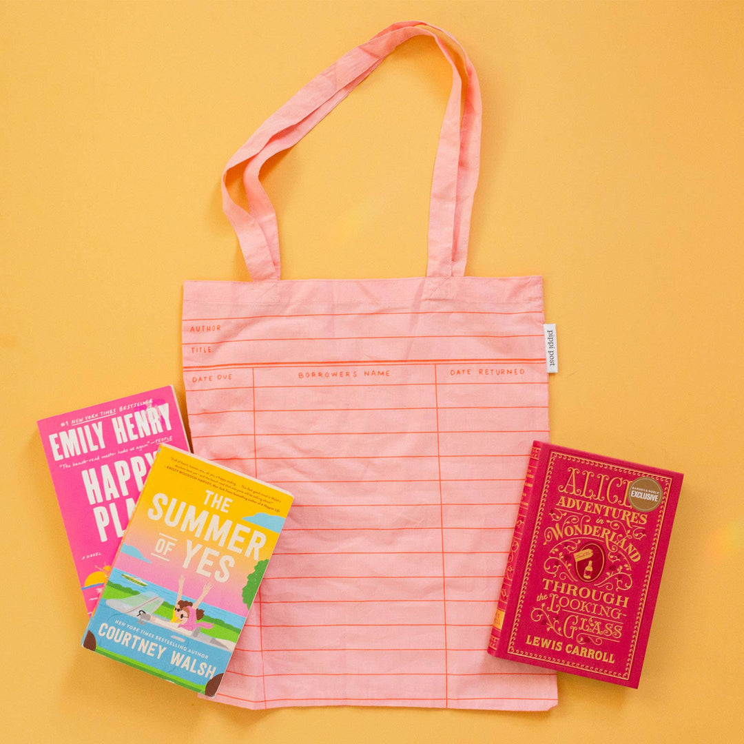 Pink tote bag with grid pattern and books on a yellow background