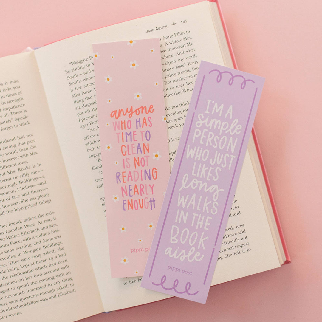 Two bookmarks with humorous text on an open book against a pink background