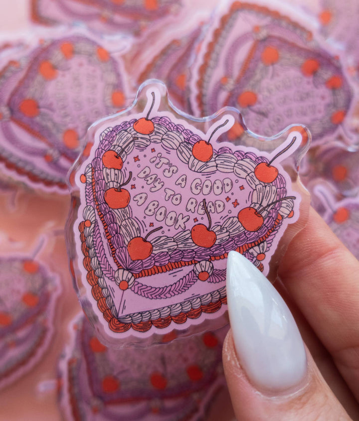 Hand holding a decorative sticker with text and cherries against a patterned background