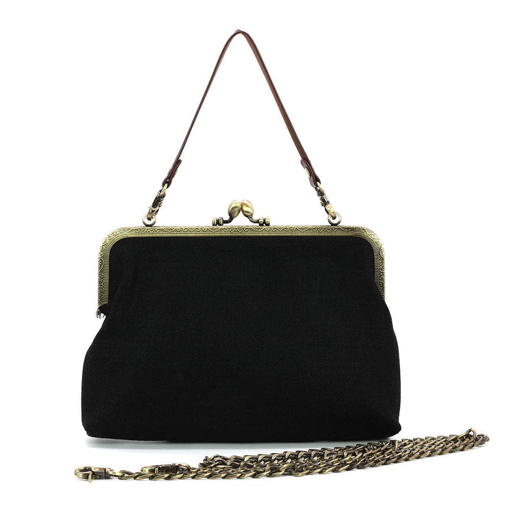 Black handbag with gold chain and frame on a white background