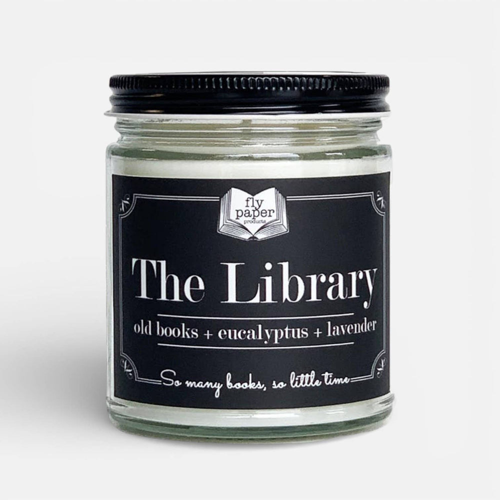 Candle jar labeled 'The Library' with a black lid on a light gray background