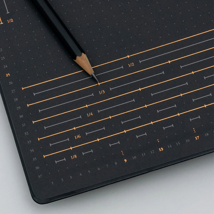 Black ruler with measurement markings on a gray surface