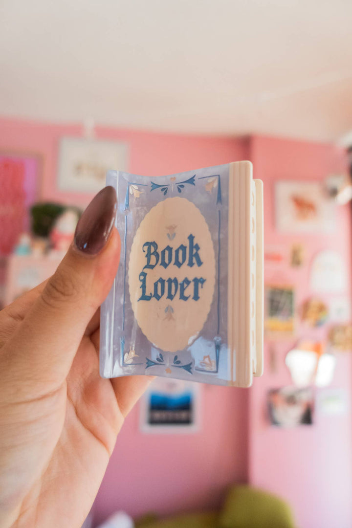 Hand holding a small book with &