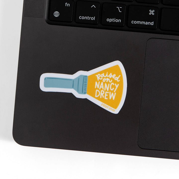 Laptop with a sticker of a flashlight and text on the palm rest area