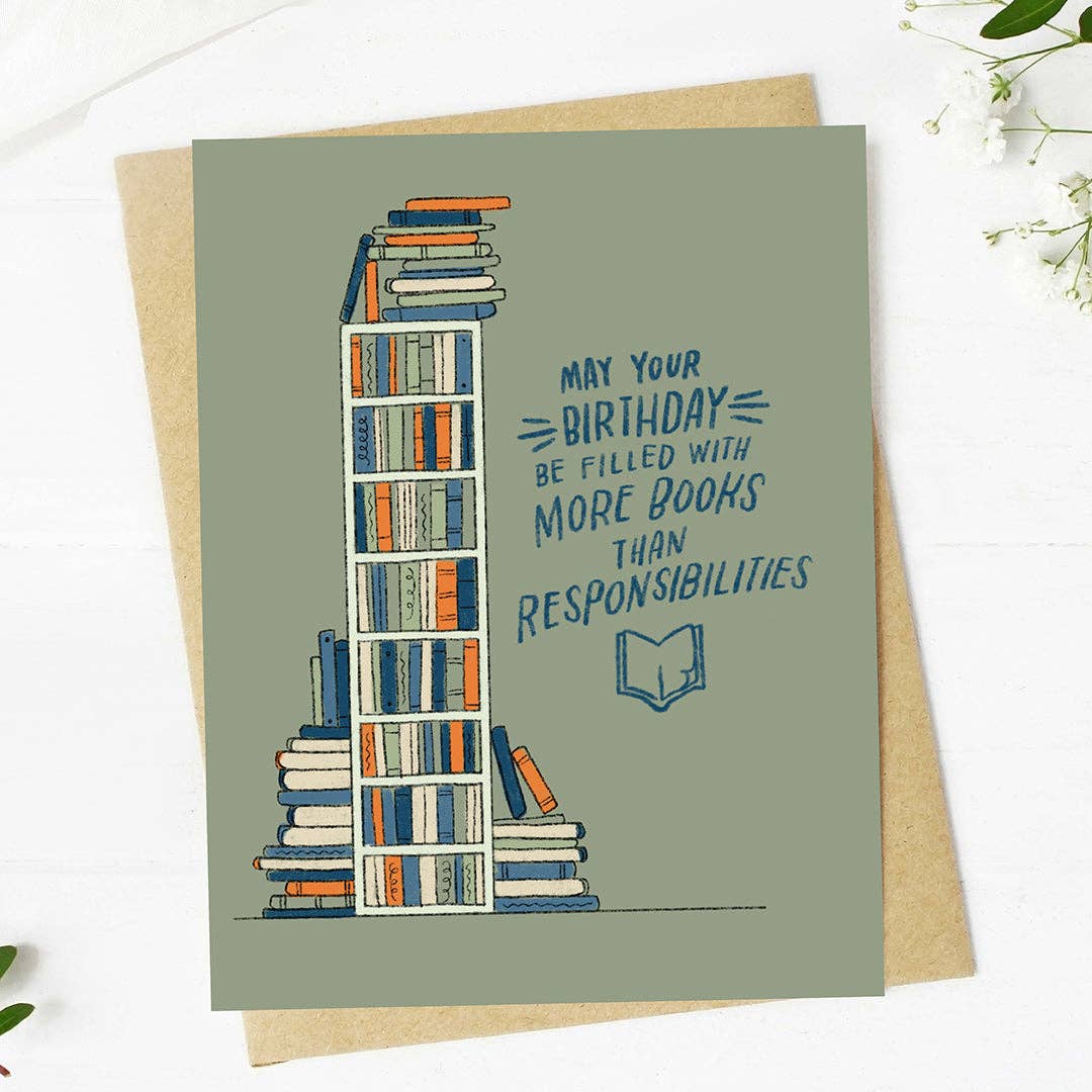 Greeting card with book illustration and birthday message on a white background. Text reads &