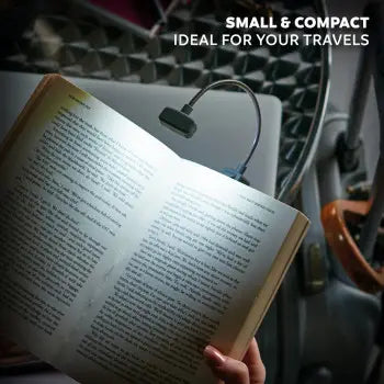 Reading lamp attached to an open book held by a person, with text 'Small & Compact Ideal for Your Travels' above.