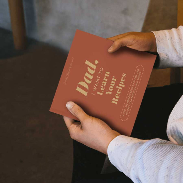 Person holding a book titled &