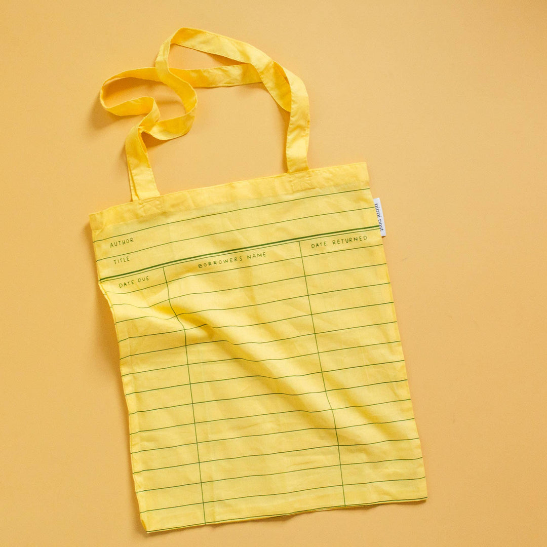 Yellow tote bag with grid pattern on a beige background