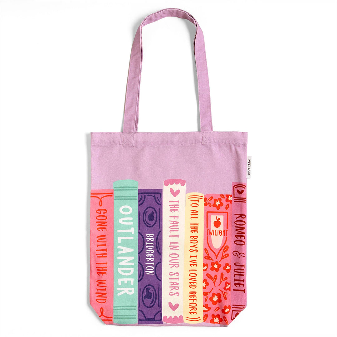Pink tote bag with book title designs on a white background