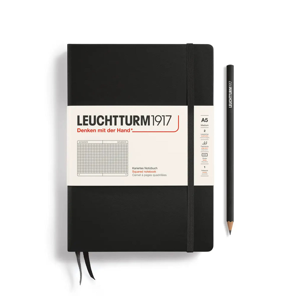 Black notebook with a pencil on a white background, featuring Leuchtturm1917 branding.