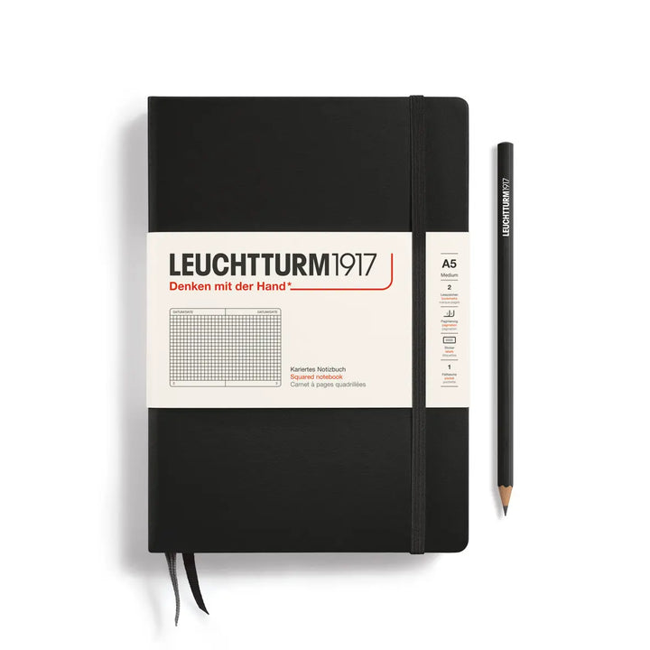 Black notebook with a pencil on a white background, featuring Leuchtturm1917 branding.