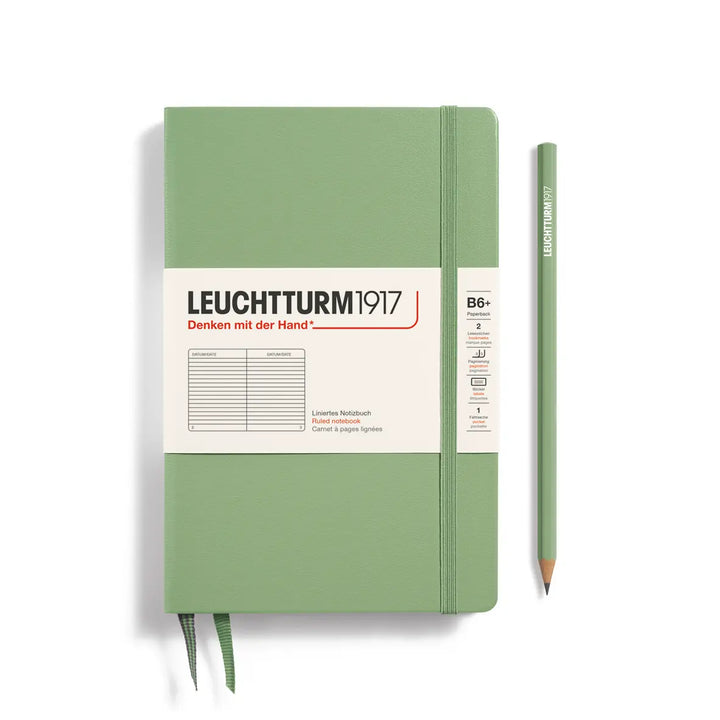 Green notebook with Leuchtturm1917 branding and a pencil on a white background